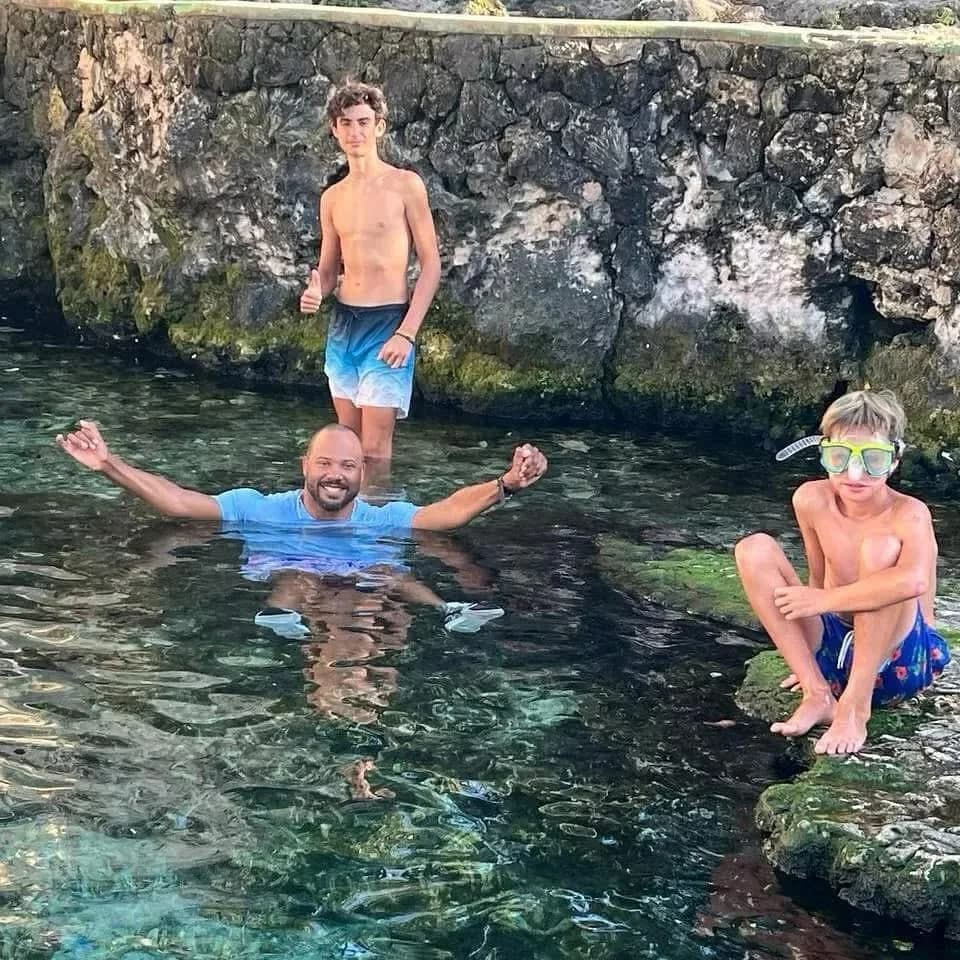 Turistas y niños en la piscina natural